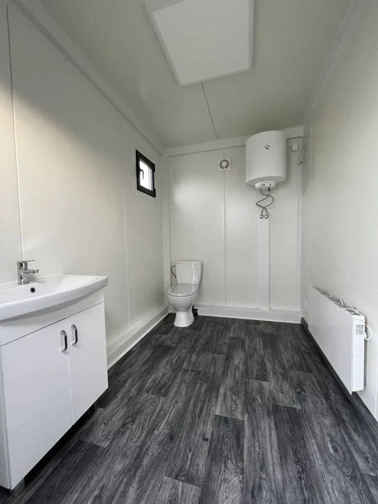 Unité sanitaire avec douche et toilettes séparées.